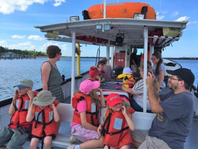 group of kids and adults sitting on charter boat during tour