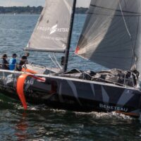 Beneteau Figaro 3 sailboat sailing in water with 4 people onboard