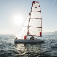 Beneteau First 14 sailboat with white sails on water