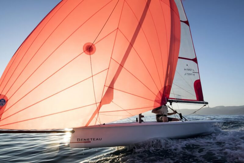 Beneteau First 14 sailboat with open sail on the water