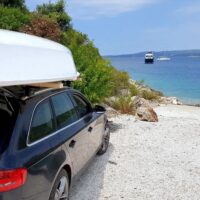 A Beneteau First 14 SE sailboat on top of a car