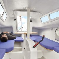 man lying down in interior of a Beneteau First 24 SE