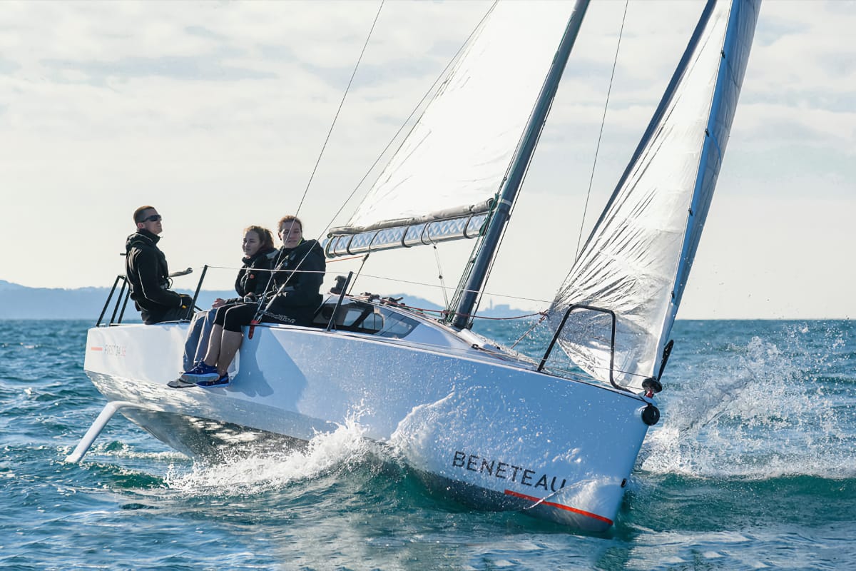 three people sailing on a Beneteau First 24 SE