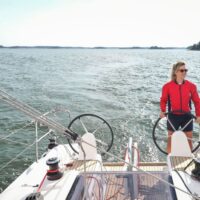 woman in red at helm of a Beneteau Oceanis 30.1