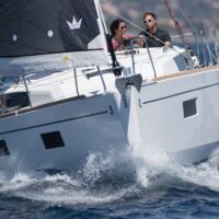 couple hitting waves while sailing a Beneteau Oceanis 38.1