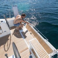man leaning over deck of a Beneteau Oceanis 38.1