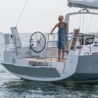 woman pushing down ladder at stern of a Beneteau Oceanis 38.1