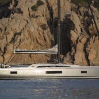 Beneteau Oceanis 51.1 side view with sail down in front of cliff