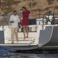 couple enjoying time with wine glasses on the stern of a Beneteau Oceanis 51.1