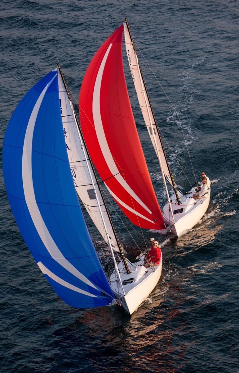 two J Boats J/70 with full sails, one blue, one red