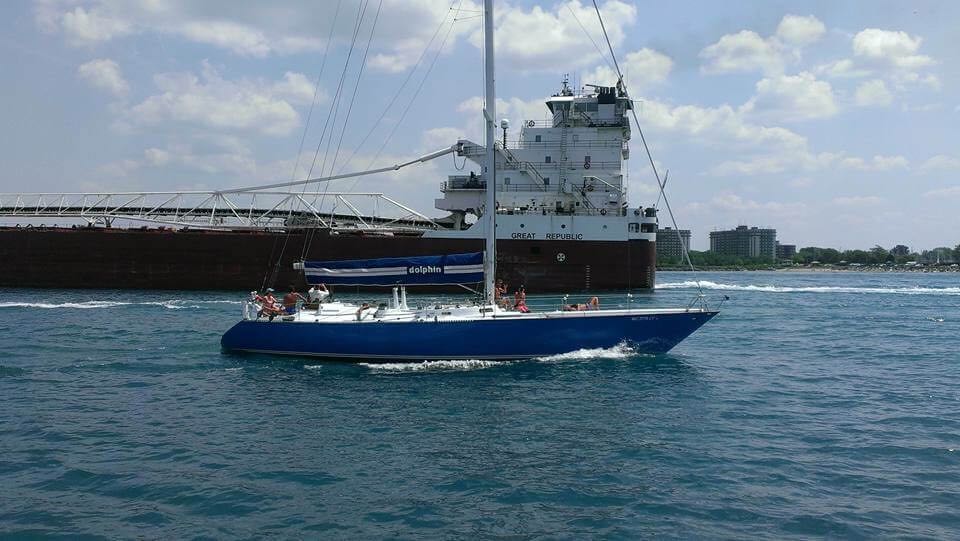 1973 Mull 54 with sails down passing a freighter