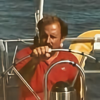 Owner and President Chester Kolascz navigating a sailboat