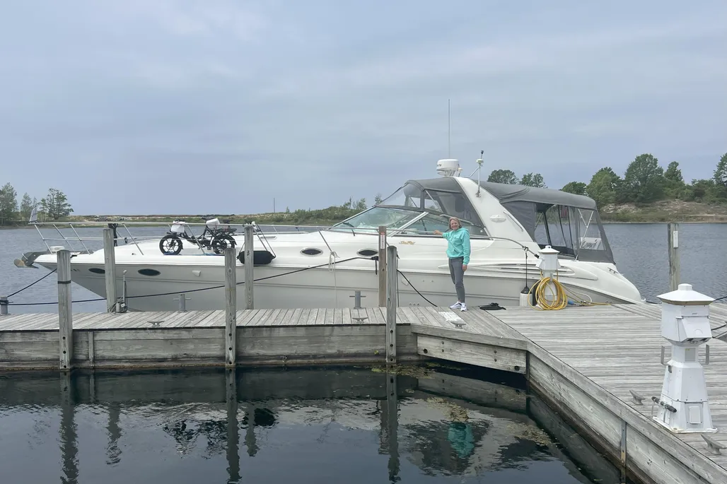 1997 Sea Ray 400 Sundancer docked with woman standing next to boat