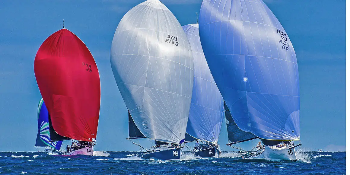 Four J-Boat J/111 sailboats in open water during a race.