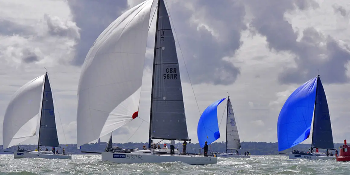 Four J-Boat J/111 sailboats in water during a race.
