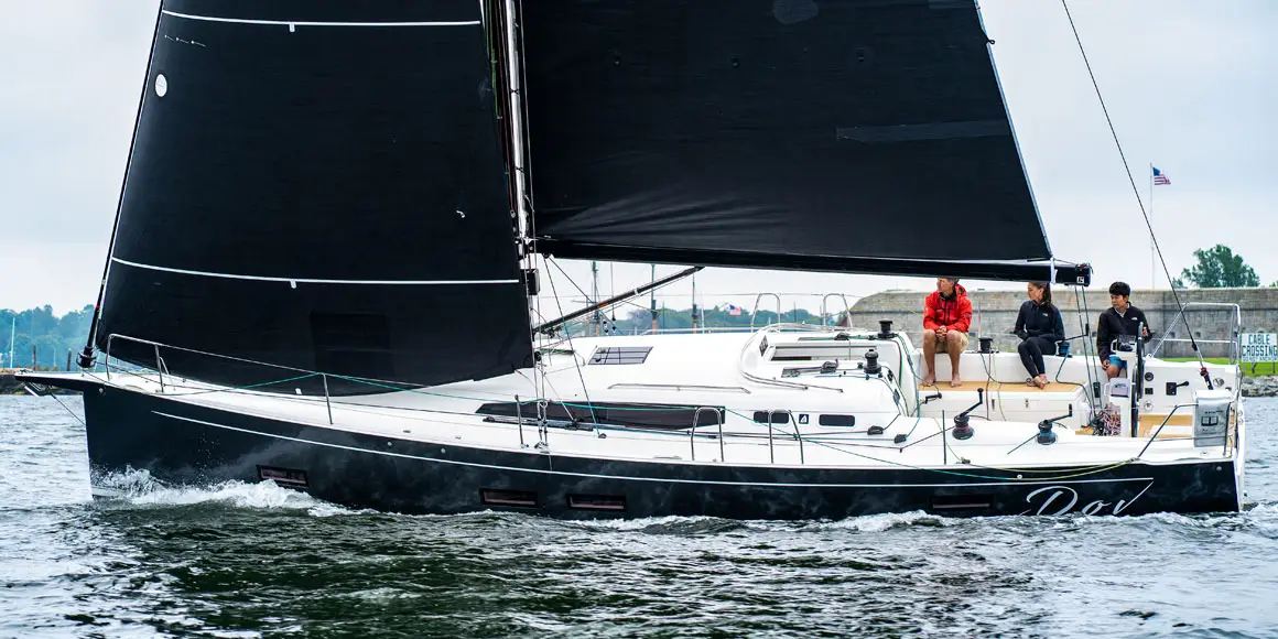 Three sailors on a J-Boat J-40 sailboat.