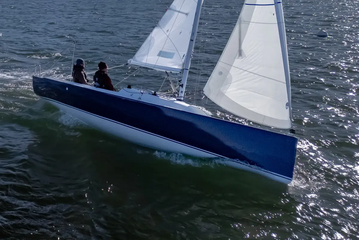 Two people sailing a J-Boat J-7 sailboat on open water.