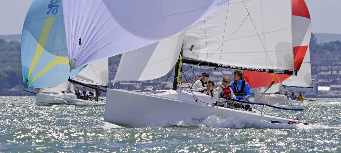 Racing crew sailing a J-Boat J70 sailboat.