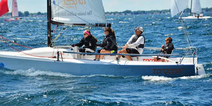 Racing crew sailing a J-Boat J70 sailboat.