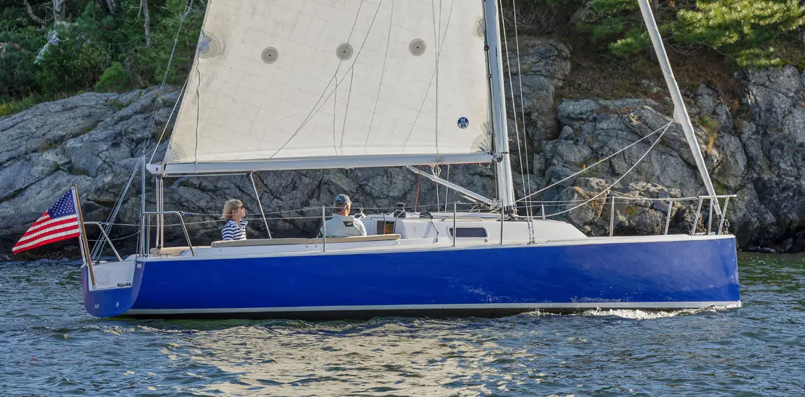 Two people sailing a J-Boat J/9 sailboat.