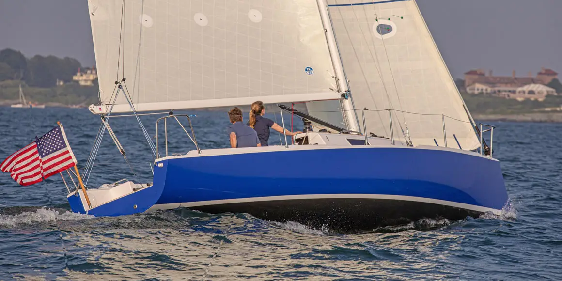 Two people sailing a J-Boat J/9 sailboat.