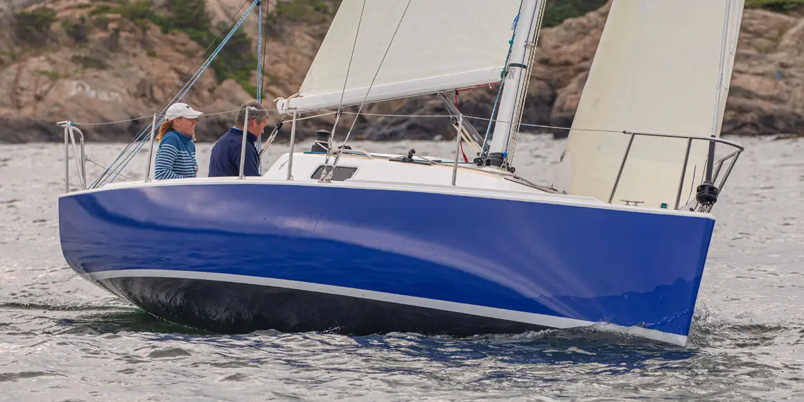Two people sailing a J-Boat J/9 sailboat.