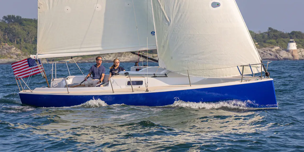 Two people sailing a J-Boat J/9 sailboat.