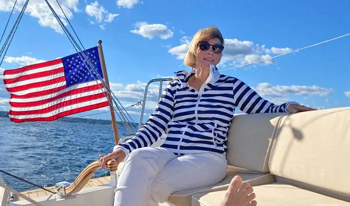 Woman sitting comfortable on deck of a J-Boat J/9 sailboat.