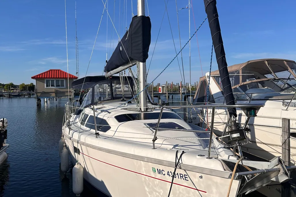 Front angle view of a 1997 Hunter 336 sailboat docked in a marina.