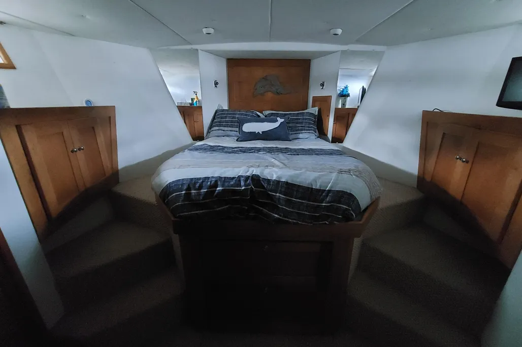 Spacious stateroom with large bed on a 2003 Dovercraft 43 powerboat.