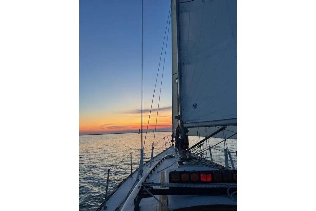 View looking out over the bow of a 1984 Catalina 38 sailboat in water.