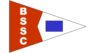 A red and white sailing pennant logo for the Bark Shanty Sail Club (BSSC), featuring the letters BSSC stacked vertically and a blue rectangle.